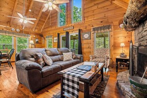 Living room with fireplace, tv, deck access, and vaulted ceilings at Cloud 9, a 1-bedroom cabin rental located in Pigeon Forge