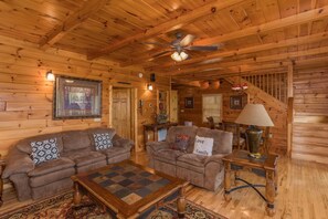 A sofa and loveseat in the living room at Howlin' in the Smokies, a 2 bedroom cabin rental located in Pigeon Forge