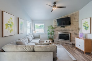 Main living room area w/ large TV & fire place
