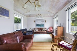 The living area is a comfortable space to unwind in air-conditioned comfort, offering three two-seater lounges, armchairs and a central TV.