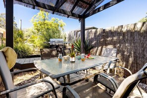 Step outside to enjoy the home's spacious, shaded patio—fit with a glass table to accomodate all guests for some alfresco dinning.