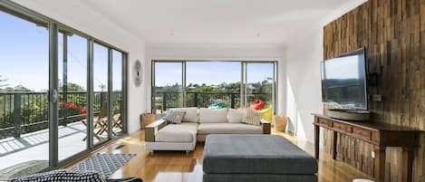 Open plan living is framed by sliding glass doors that lead out to the oversized deck. Kick back on the comfortable lounges with a spot of TV.