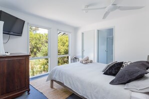 The primary bedroom is set with a comfortable queen bed under a ceiling fan. Kick back and watch TV and indulge in a relaxing shower in the attached ensuite. 