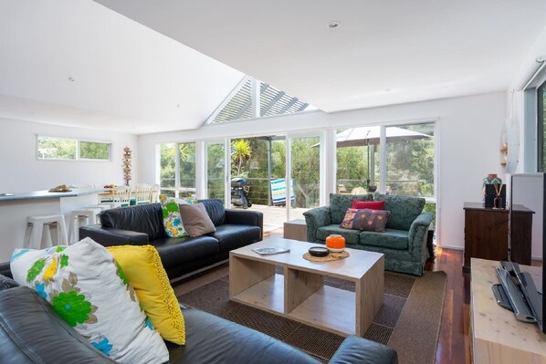 Pitched, soaring ceilings, timber floors and wall-to-wall windows adorn the open plan living area, creating a comfortable area for the group to gather and drenching the space in natural light. 