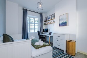 Bedroom 2 benefits from a comfortable king bed, a desk with monitor and plenty of storage.