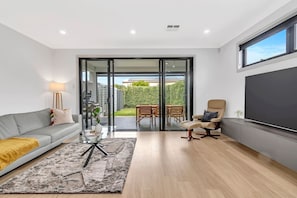 Guests can settle in with a movie in the living area, which is complete with a large sofa and a TV, while a cosy armchair by the door is perfect for a relaxing afternoon read. 
