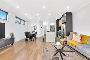 Enjoy the open-plan living area with seamless transitions to the dining space or kitchen, perfect for gathering with your group.