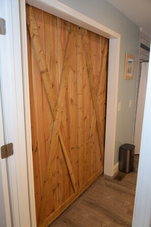 Hand made custom barn door separates laundry area from bathroom.