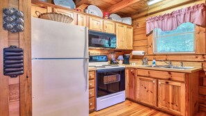 The kitchen has an oven/stove, refrigerator and cupboard/pantry space.