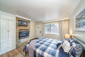 Main living area, queen memory foam mattress, Smart TV, and gas fire place. View from kitchen.