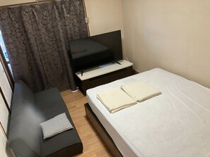 ・[402・Bedroom] A sofa and a large screen TV are installed.