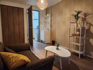 Living room: Chairs, table, air conditioner, WiFi, flame retardant curtains, detector