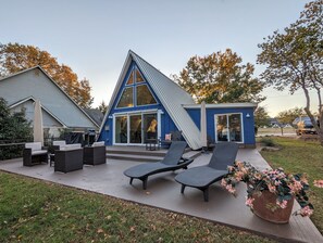 Back patio has several seating areas, 2 umbrellas and a gas Weber grill. 