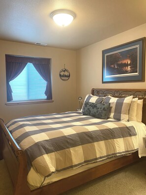 Down the hallway from the entertainment room, a plush and cozy Queen bedroom awaits.