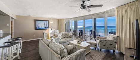 The living room offers ample, comfortable seating, a flat screen television, and incredible views of the beach.
