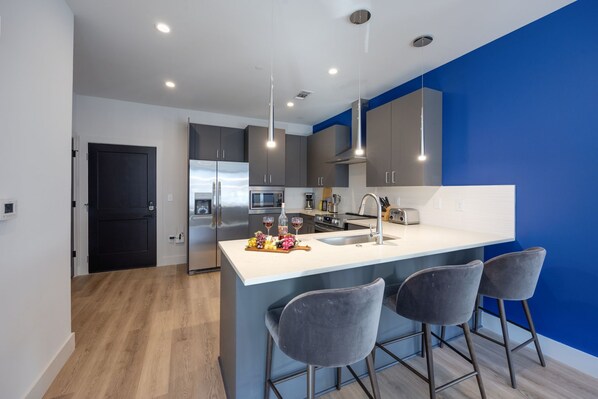 Fully equipped kitchen stocked with your basic cooking essentials, stainless-steel appliances, and breakfast bar seating.