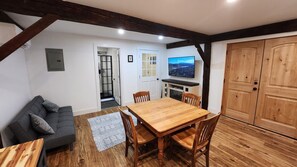 Living and dining areas, with convertible futon/couch, electric fireplace, and smart TV