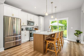 The Butterfly House Features a Gorgeous Kitchen Area with Sleek Stainless Steel Appliances and an Island