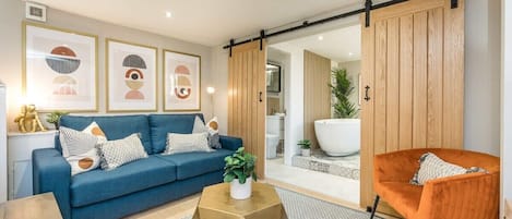 The beautiful open plan living area with sliding oak barn style doors opening out into the master suite