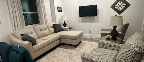Cozy living room! Two oversized chairs and a sofa with a lounger. Wall mount TV.