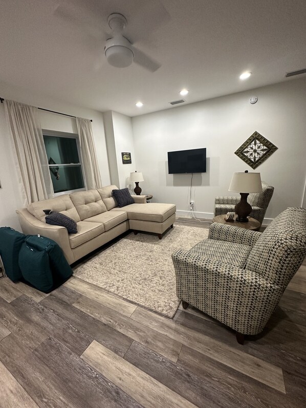 Cozy living room! Two oversized chairs and a sofa with a lounger. Wall mount TV.