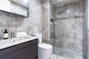 This modern bathroom boasts a sleek aesthetic with a stylish shower, creating a clean and elegant space for your daily routines.