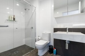 Unwind in a modern bathroom that features a clean, minimalist shower for a refreshing and stylish experience.