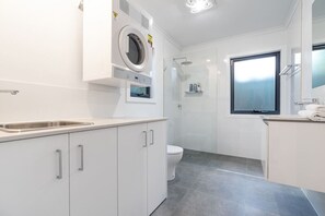 Contemporary laundry and bathroom with modern fixtures and practical design, providing a stylish and functional experience.