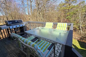 Grill with sitting area. Grill has a propane tank attached 