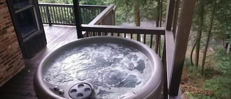 Covered hot tub on the deck overlooking the river.
