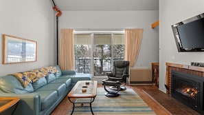 Cozy Living Room with Gas Fireplace and balcony through sliding doors
