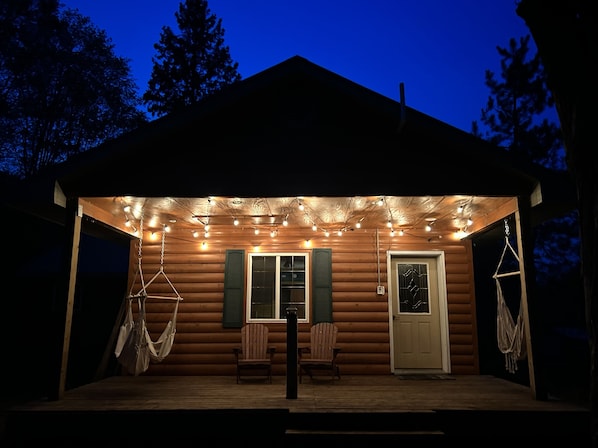 Covered porch includes both Adirondack and hammock chairs.