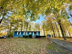 This home is surrounded by towering sugar maple trees.