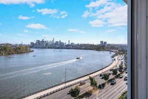 Enjoy panoramic views of the Brisbane River through expansive glass windows in the living room.