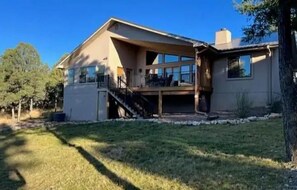 Back of home with covered porch and yard to play in.