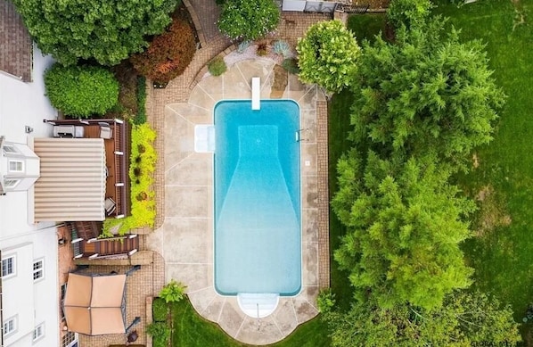 Summer view of the pool and yard area.