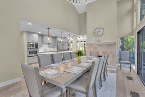 Adjacent to the kitchen, a charming dining room features a coastal table, perfect for gathering and dining in style.