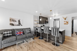 Living area with a mounted TV over a gas fireplace, a queen sleeper sofa, and balcony access.