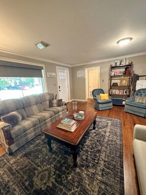 The front door leads to a spacious living room — complete with two sofas, two swivel chairs, books, television, and a turntable with dozens of classic country LPs.