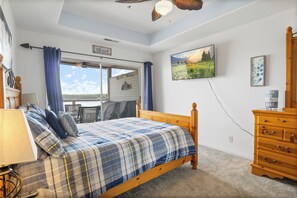 A cozy oasis with a comfortable bed, stylish dresser, elegant mirror, and entertainment-ready television.