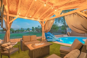 Captivating scenery with a covered fire place beside the relaxing pool.