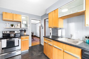 This kitchen is both stylish and functional. The stainless steel appliances and wooden cabinets make it the perfect place to cook and entertain.