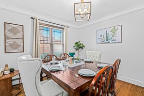 The dining room is equipped with a chandelier and sconces for warm and inviting lighting