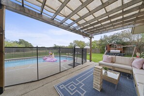 Swimming pool with pool fence and a covered patio adjacent