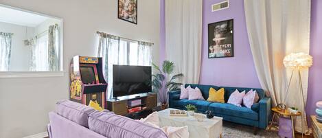 Gorgeous living room with sofa, tv, arcade game and curtain decors