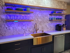 A luscious kitchen with LED lighting , silverware, basic spices and coffeeMaker