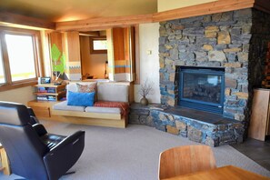 Smart TV is hidden behind bench wall between living room and bedroom