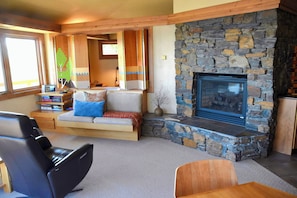 Smart TV is hidden behind bench wall between living room and bedroom