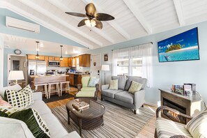 Enter the front door between the kitchen/dining areas & the living area. A 2nd door (behind you in this photo) leads to the covered oceanfront deck.