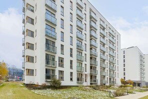  Exterior shot of a modern residential building with multiple floors and large windows.